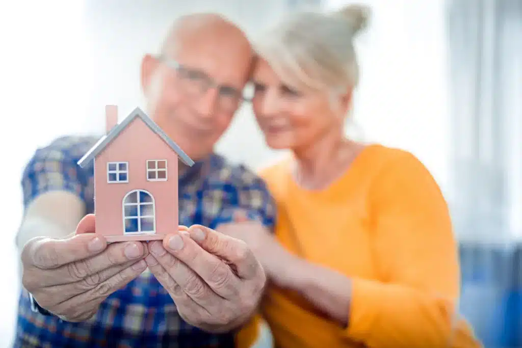 Lovely couple with a portrait of their house